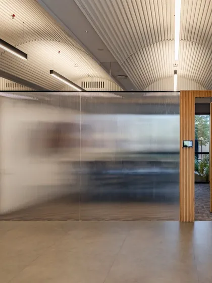 In the revisited UTI HQ, a translucent wall creates a soft, diffused light effect, separating spaces while maintaining a sense of openness and connection.
