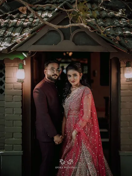 A classic portrait of the couple standing in a rustic doorway, ready to celebrate their union with friends and family.