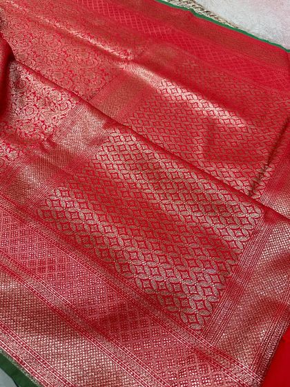 A closer look at the rich red pallu of a Banarasi silk saree, showcasing the intricate diamond jaal weaving in gold zari.