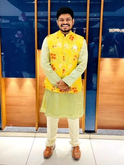 A vibrant look perfect for a Haldi ceremony. This ensemble features a light pista green kurta with a contrasting floral print bandi jacket, offering a fresh and celebratory style.