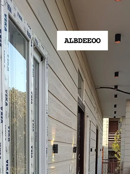 A series of detailed shots of a terrace prefab house's exterior. These images focus on the wood-textured cement plank elevation, modern ceiling lights, and high-quality VEKA window frames.