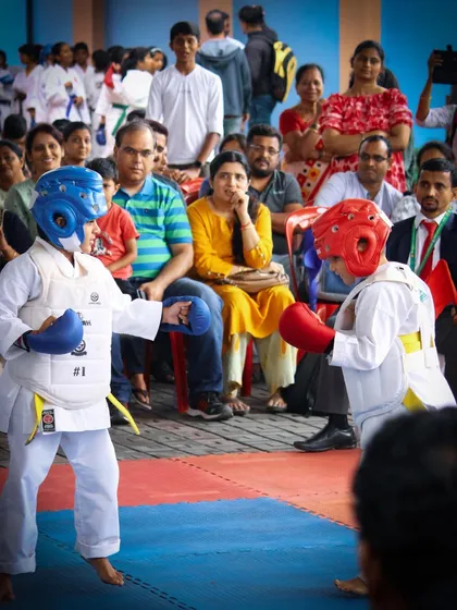 A Kumite match in progress, highlighting the protective gear and matted competition area we use to ensure student safety.