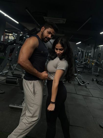 A fun moment flexing together. Having a workout partner keeps things light and motivating.