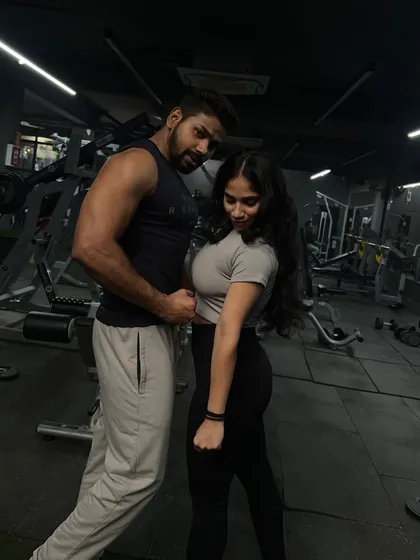 A fun moment flexing together. Having a workout partner keeps things light and motivating.