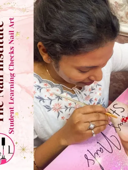 A student practices creating a detailed design with red crystals, learning how to apply embellishments securely.