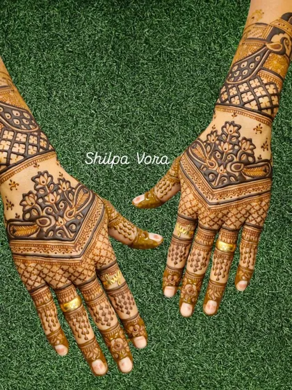 A beautiful V-shaped design with paisley and floral elements, creating an elegant and elongated look on the hands.