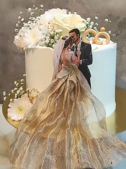 Make your cake deeply personal with an edible print of your favorite photo. Here, I created a beautiful topper from a couple's picture, complemented by elegant white frosting and a spray of fresh baby's breath and white flowers.