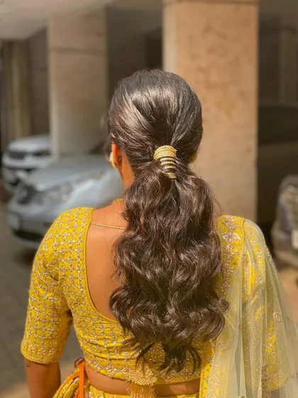 The back view of the simple waved ponytail. It's a timeless and elegant choice for any event.