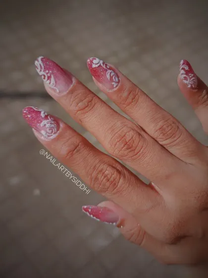An intricate bridal design with a pink glitter ombre base and raised white 3D scrollwork for a textured, elegant finish.