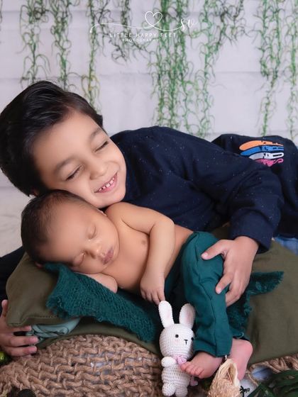 The smile on this big brother's face says it all. He is so happy to be cuddling his new baby brother.
