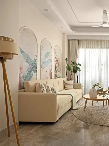 The living room is bathed in natural light, with a tripod floor lamp adding a warm glow in the corner. The entire space is designed to feel like a sanctuary, where the design itself breathes.