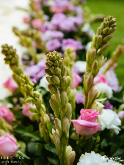 A close-up of the fresh flowers used in the aisle arrangement, featuring beautiful tuberose buds, pink roses, and carnations.