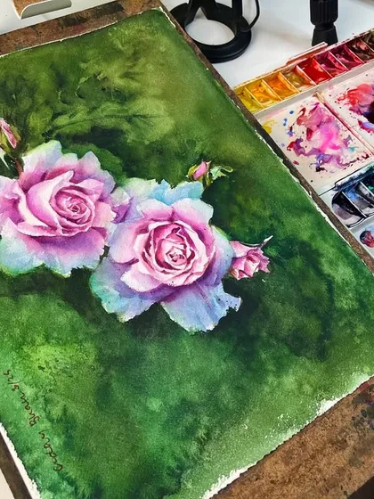 The finished flower painting on my easel, next to the palette used to create it. This shows the connection between the colors I mix and the final result on paper.