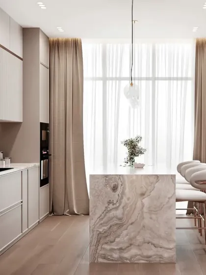 A bright and airy kitchen design, with large windows letting in natural light. The minimalist cabinets and marble island create a feeling of spaciousness.
