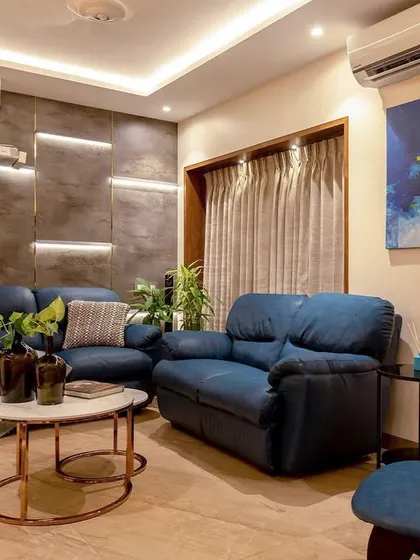 The feature wall in this family room has textured panels with integrated backlighting, creating a dramatic and cinematic atmosphere. The ceiling-mounted projector indicates a dedicated home theater setup.