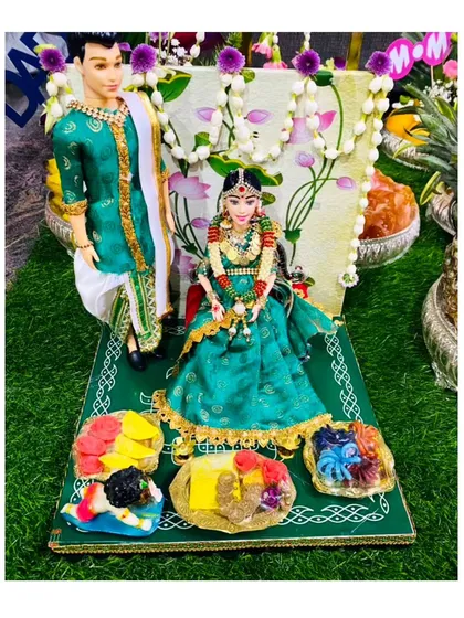 My handmade ceremonial dolls are a signature offering, perfect for adding a personal touch. This couple, dressed in traditional green attire for an engagement or wedding, sits on a custom-decorated platform, ready to be the centerpiece of your celebration.