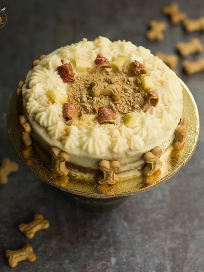 This is my super popular Apple and Peanutbutter cake, looking absolutely delicious! I decorate it with creamy frosting, crunchy dog biscuits, and fresh apple pieces. It's a healthy and beautiful centerpiece for any dog party.
