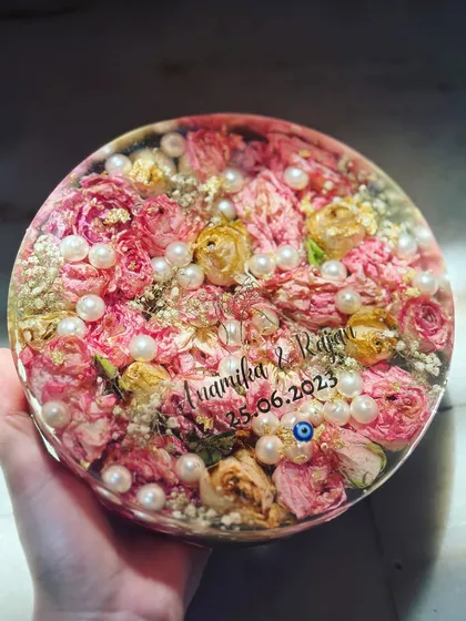 The details in this 7-inch circular varmala preservation are so special. The texture of the dried roses, the shimmer of the gold flakes, and the scattered pearls all come together beautifully.
