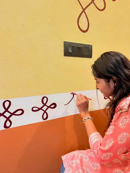 Here I am carefully painting traditional rangoli-style patterns at a client's house entrance. These minimal designs add a touch of elegance and cultural heritage to the home's entryway.