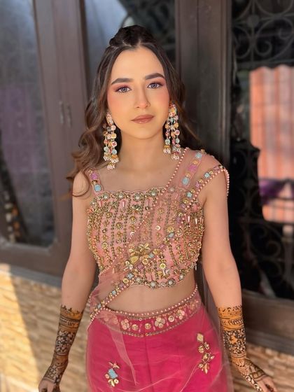 This soft and pretty Mehendi look features a pop of pink on the eyes to match her outfit. It's a fun, fresh, and sun-kissed style perfect for a daytime event.