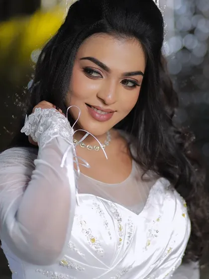 A smiling model in a white gown, showcasing a beautiful Christian wedding look. The makeup is soft and romantic, perfect for the occasion.