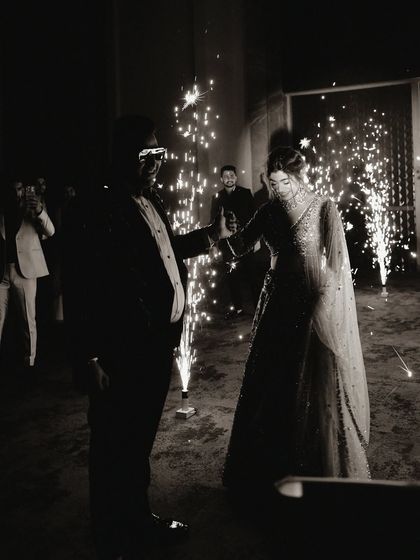 A magical entrance for the bride and groom, surrounded by sparklers. This black and white photo beautifully captures the celebratory mood of a reception party.