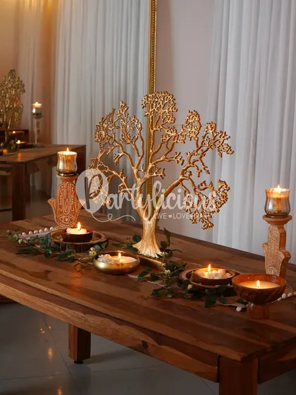 The warm glow of candlelight on a beautifully styled table sets the mood for any festive gathering. This setup features a golden tree console, creating a focal point that is both elegant and timeless.