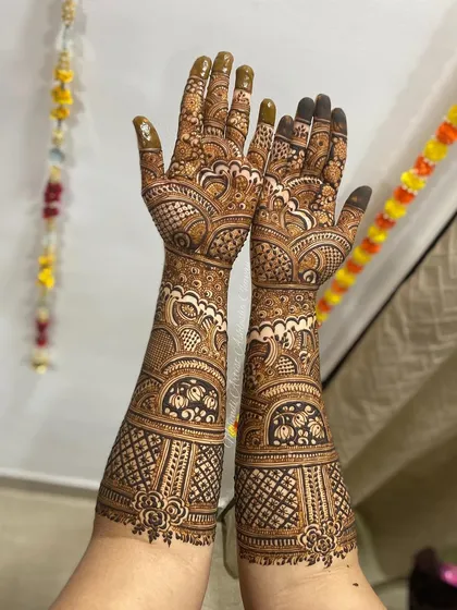 A full-arm mehendi design with a mix of traditional patterns. The design is dense and intricate, perfect for a bride or a grand celebration.