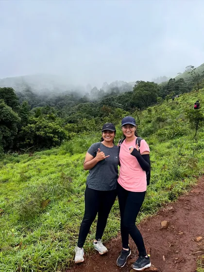 Two friends posing on the Bandaje trail, with the misty, green valley behind them. The views are spectacular at every turn.