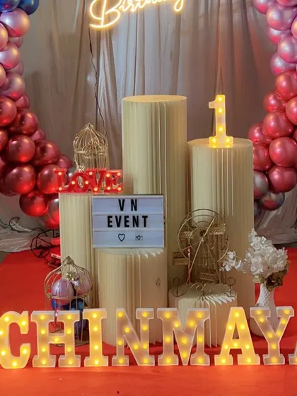 A close-up of the props for a first birthday party. We provide marquee letters for the name, like 'CHINMAYA' here, along with a number '1' light and other decorative items.