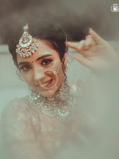 A bride's portrait should capture her essence. Here, I used a soft, dreamy style to highlight her gentle smile and the intricate details of her nath and maang tikka, creating a timeless and ethereal image.