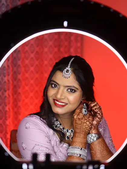 A perfect shot with the ring light. This image captures the flawless finish of the reception makeup, from the bold red lip to the perfectly blended foundation.