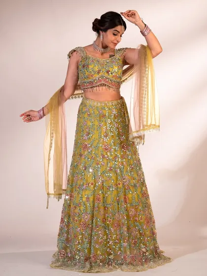 This lime green lehenga is a burst of freshness. The multi-color floral embroidery and sequin work make it a standout piece for any festive occasion.