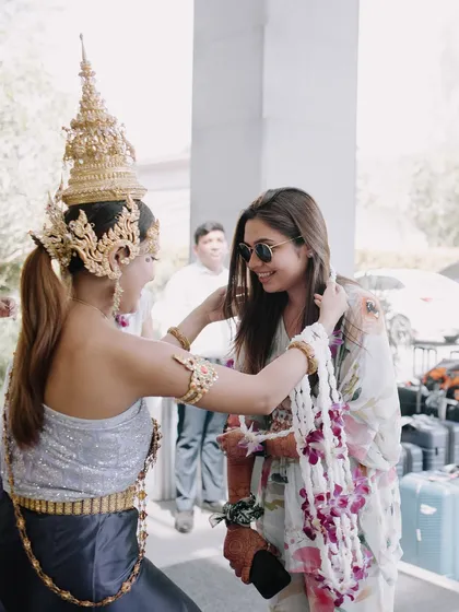 A guest being welcomed in traditional Thai style with a floral garland, a beautiful way to honor the destination and make guests feel special.