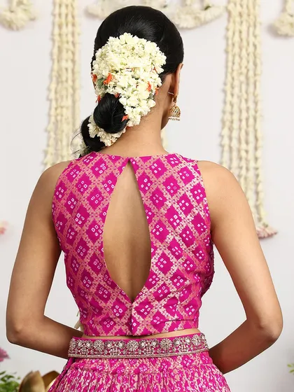 The back of the Bandhani blouse features an elegant keyhole design, adding a touch of modern sophistication to this traditional ensemble.