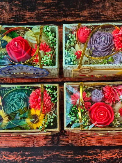 An overhead view of four completed Flower Bouquet Gift Hampers. I love how the colors of the floral candles pop, creating a vibrant and joyful gift box perfect for any celebration.