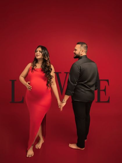 Bound by love. This stylish portrait, with the couple holding hands against a red backdrop with the word "LOVE," is a modern and powerful declaration of their partnership.