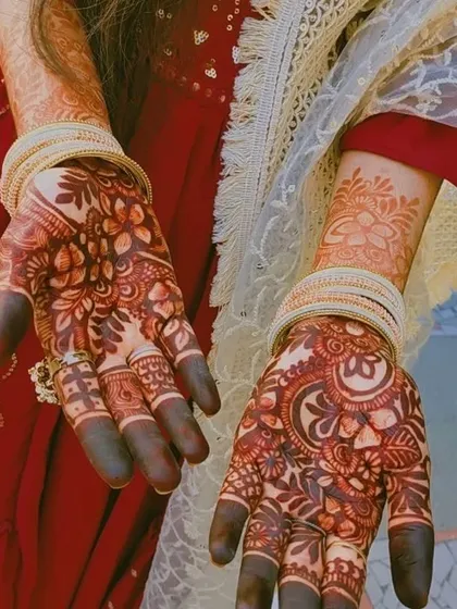 The beautiful contrast of the dark henna stain against the bride's traditional red attire. It's a classic and timeless combination.