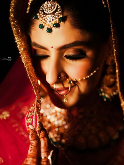 A soft and intimate close-up of the bride. Her gentle smile and the warm, dramatic lighting create a deeply romantic and beautiful portrait.
