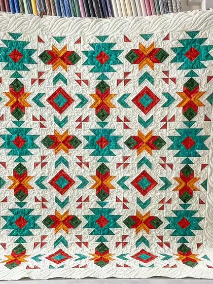 A quilt with a vibrant, geometric pattern inspired by Southwestern designs.