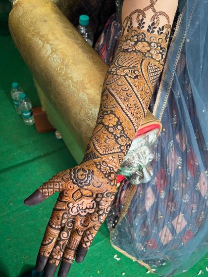 A unique design featuring the bride's name 'Saif' on the palm, surrounded by a mix of diagonal patterns and floral motifs.