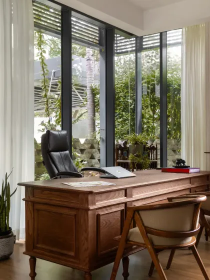 A large wooden desk is positioned to take advantage of the view, making work feel less like a chore. The space is professional yet deeply personal.