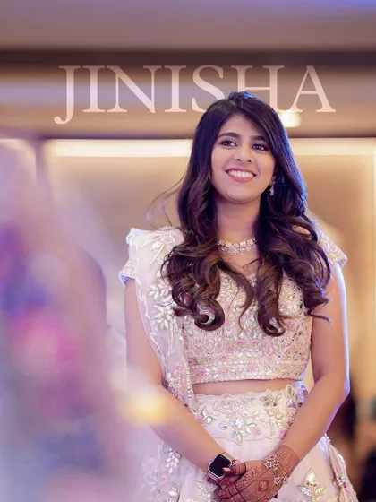 A glowing and happy wedding guest. Her makeup is soft and natural, with a focus on a radiant complexion that shines in the photo.