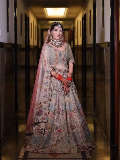 A full-length portrait of the bride in her unique and colorful lehenga. The makeup is kept classic and elegant to balance the vibrant outfit.
