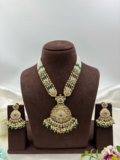 Our "Indira" premium antique gold necklace set. This long necklace features a large, intricately designed pendant with Meenakari work and comes with matching statement earrings.