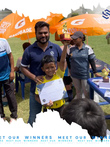 A young player proudly holds his trophy and certificate alongside his coach. These moments of recognition are crucial for building a young athlete's confidence and love for the game.