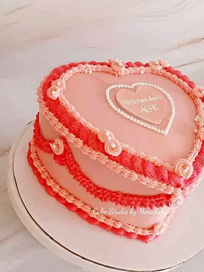 Vintage heart-shaped cakes are back, and I love putting my own spin on them. This design uses intricate buttercream piping in shades of pink and red for a romantic, nostalgic feel that's perfect for anniversaries or birthdays.