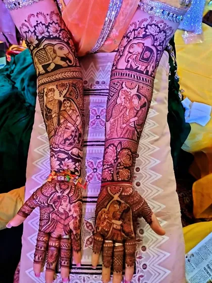 This design is a masterpiece of figurative work, showing various wedding rituals and scenes on the arms. The palms feature portraits of the bride and groom, making it a cherished part of the wedding.