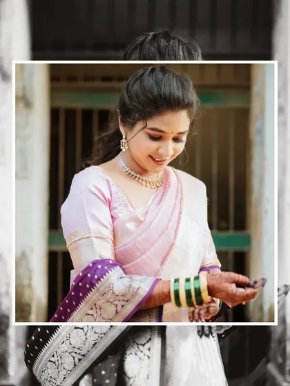 A beautifully framed portrait of the bride. The black and white background makes her colorful saree and delicate expression the sole focus of the image, highlighting her grace.