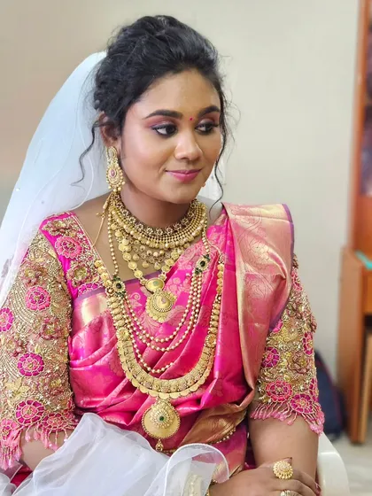 Another angle of the bride who combined a pink saree with a white veil for her Christian wedding. The makeup beautifully ties the two elements together.
